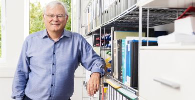 LGC employee leaning against bookshelves