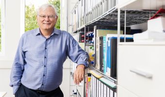 LGC employee leaning against bookshelves